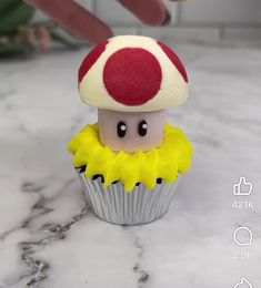 a small toy mushroom sitting on top of a cupcake