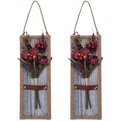 two pieces of wood with flowers hanging from the handles on each side, one is holding a pair of scissors