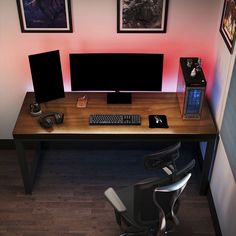 a computer desk with two monitors and a keyboard on it in front of pictures hanging on the wall