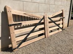 a wooden fence with metal bars on the top and bottom, next to a building