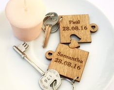 personalized wooden keychains with names and date engraved on them sitting on a plate next to a candle