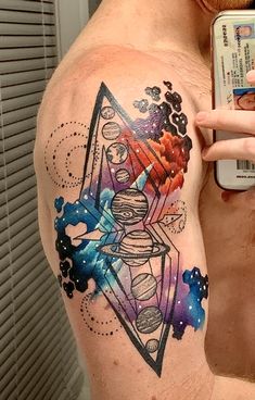 a man with a colorful tattoo on his chest holding a cell phone to his ear