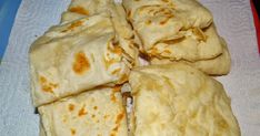 four pita breads cut into squares on a towel