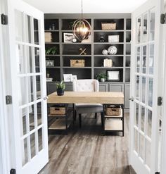 an open door leading to a room with white doors and shelves filled with bookshelves