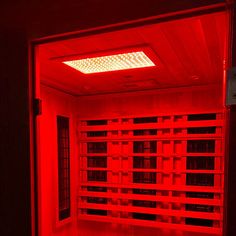 a red light is shining on the wall in a room with many shelves and drawers