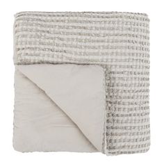 a white and grey blanket folded on top of each other