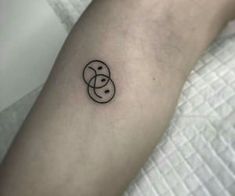 a small tattoo on the arm of a woman's left arm, with a smiley face