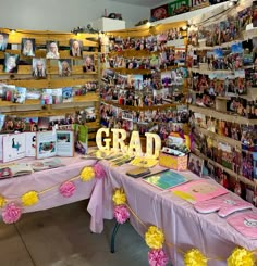 a pink table topped with pictures and flowers next to a sign that says grad