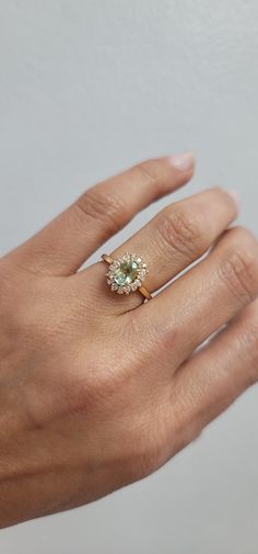 a woman's hand with a gold ring and an aquamarine colored diamond on it