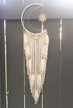 a white dream catcher hanging from the side of a wall