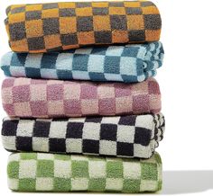 four towels stacked on top of each other in different colors and patterns, all folded neatly