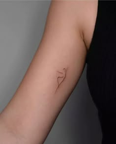 a woman's arm with a small heart tattoo on the left side of her arm