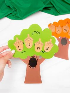 a person holding up a cut out of a tree with the words luna on it