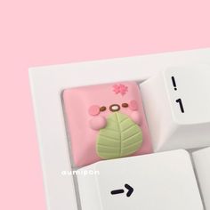 a cell phone case sitting on top of a computer keyboard with a pink flower in the middle