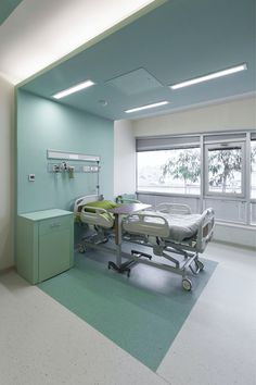 an empty hospital room with green and white walls