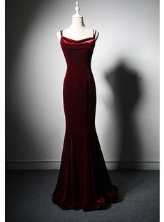 Arranged with meticulous attention to detail, this stunning prom dress captures the essence of classic glamour and modern sophistication. The luxurious burgundy velvet fabric not only looks exquisite but also feels incredibly soft and comfortable against the skin. The dress features a flattering silhouette that hugs your curves, while the draped neckline and slim spaghetti straps add a touch of delicate femininity. The floor-length design creates a striking, elegant look that is perfect for any formal event. The rich color and sumptuous texture of the velvet ensure you stand out with confidence and grace. Ideal for proms, formal dances, or any event where you wish to leave a lasting impression, this dress is designed to make you feel like the belle of the ball. Complete your ensemble with Long Red Elegant Dresses, Deep Red Evening Gown, Dark Red Hoco Dress Long, Prom Dresses Red Velvet, Wine Red Party Dress, Prom Dress Dark Colors, Dark Red Mermaid Dress, Designer Evening Gowns Classy, Red Velvet Evening Dress