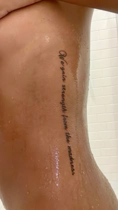 a woman's lower back tattoo with words written on it