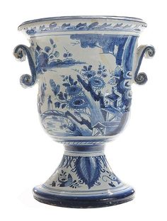 an ornate blue and white vase with birds on it's sides, sitting in front of a white background