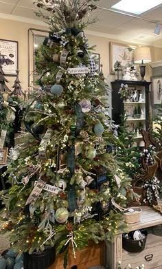 a decorated christmas tree in an office with lots of ornaments on the top and bottom