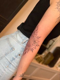 a woman's arm with a tattoo on it, and a flower in the middle