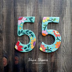 the number 55 is decorated with flowers and leaves