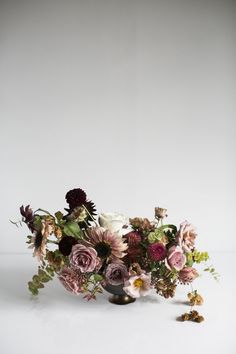 a vase filled with lots of flowers on top of a table