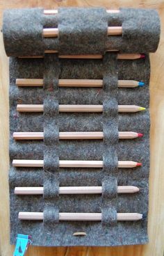 several pencils are lined up on a piece of felt