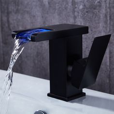 a black faucet with blue water running from it