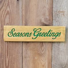 a wooden sign that says seasons greetings