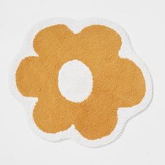 an orange and white rug with a flower on it