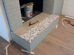 an unfinished fireplace being built with tools on the floor