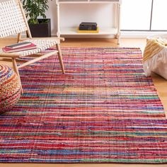 a multicolored rug in a living room with a chair and bookcase on the floor