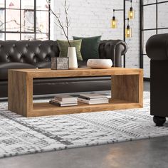 a living room with a couch, coffee table and two black leather sofas in front of a brick wall