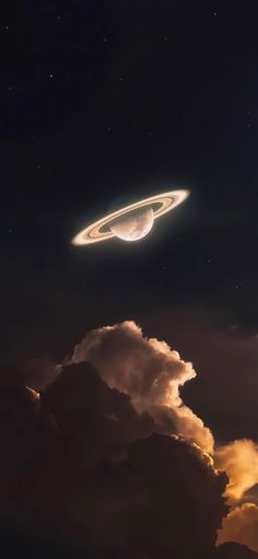 an object is flying in the sky above some clouds and stars on a dark night