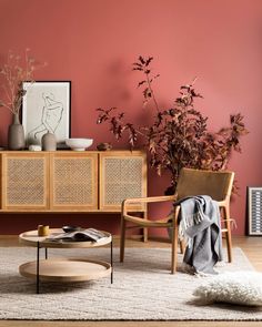 a living room with pink walls and wicker furniture in the corner, including a coffee table