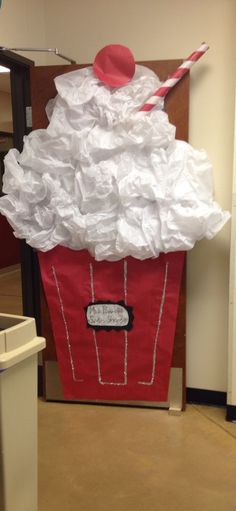 a red trash can with a white dress on it