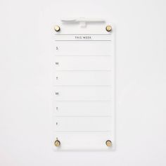 a white clipboard with three pins on it and a notepad attached to the side