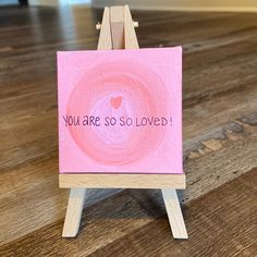 a small easel with a pink card on it that says you are so loved