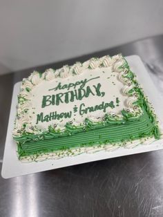 a green and white birthday cake on a table