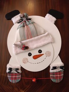 a paper plate with a snowman hat and mittens on it