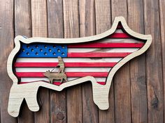 a wooden cutout of the shape of a cow with an american flag painted on it