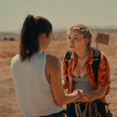 two women standing next to each other in the desert