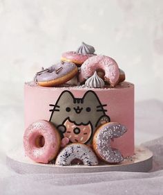 a pink cake with donuts and doughnuts on it's top tier