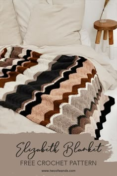 a crocheted blanket sitting on top of a bed next to a night stand