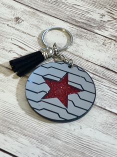 a keychain with a red star on it sitting on top of a wooden table