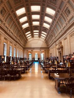 an empty library with tables and lamps on the ceiling is seen in this image,