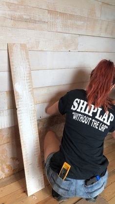 a woman sitting on the floor next to a piece of wood that says ship lap without the cap