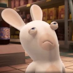 a white rabbit with blue eyes standing in front of a store filled with shelves and boxes