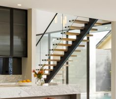 a modern kitchen with marble counter tops and stairs