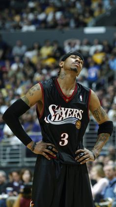 a basketball player standing on the court with his hands on his hips and looking up